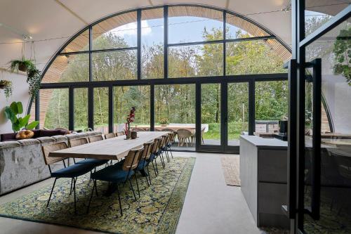 una sala da pranzo con un tavolo e alcune sedie di Bosresort Maanzicht a Noordwolde