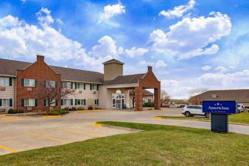 a building with a blue sign in front of it at AmericInn by Wyndham Pella in Pella