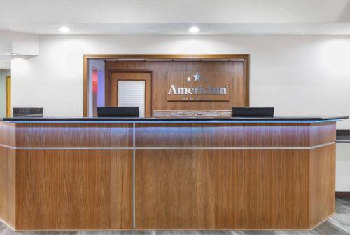 a reception desk with a sign that reads american clinic at AmericInn by Wyndham Pella in Pella