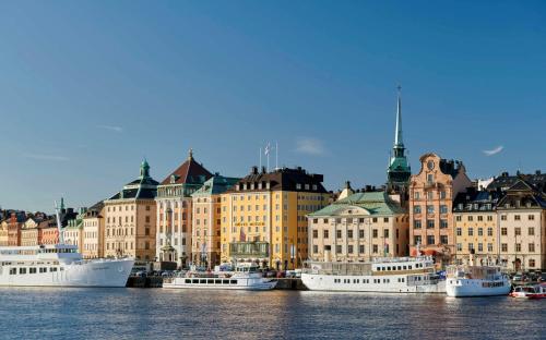 a group of boats docked in a harbor with buildings at Hôtel Reisen in The Unbound Collection by Hyatt in Stockholm