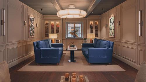 a living room with two blue chairs and a table at Hôtel Reisen in The Unbound Collection by Hyatt in Stockholm
