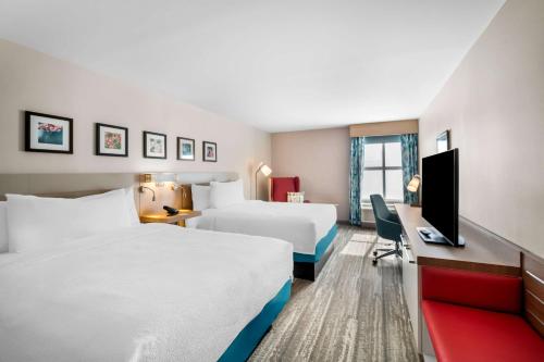 a hotel room with two beds and a desk at Hilton Garden Inn North Conway in North Conway