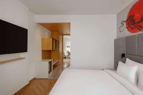 a bedroom with a bed and a tv on the wall at Ramada by Wyndham Gorakhpur Gorakhnath Mandir Road in Gorakhpur