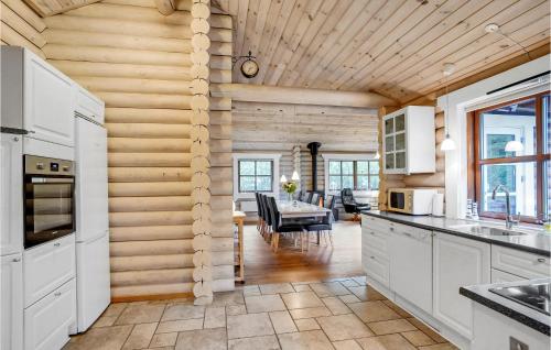 a kitchen with white cabinets and a dining room at Holiday Home Ramshule Farsø Xii in Hvalpsund