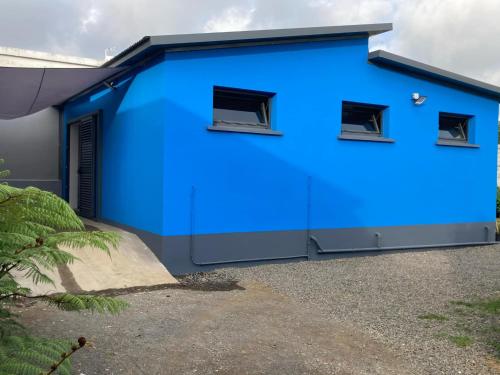 a blue building with two windows on it at l'an dormi vacances in La Plaine des Cafres