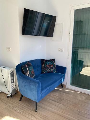 a blue couch in a living room with a tv at The Nook at Monda in Monda