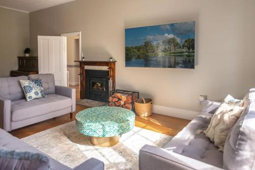 a living room with a couch and a table at The Ranch-pool Table, Table Tennis, Firepit, Piano in Stanthorpe