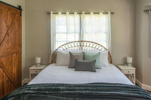 a bedroom with a bed with pillows and a window at The Ranch-pool Table, Table Tennis, Firepit, Piano in Stanthorpe