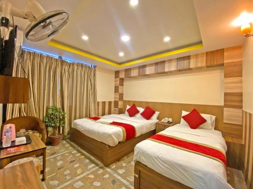 a hotel room with two beds and a desk at Hotel Airport Holiday in Kathmandu