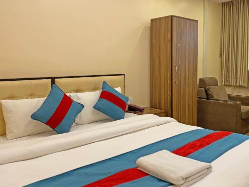 a bedroom with a large bed with blue and red pillows at Hotel Airport Holiday in Kathmandu