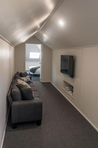 a living room with a couch and a flat screen tv at The Ranch-pool Table, Table Tennis, Firepit, Piano in Stanthorpe