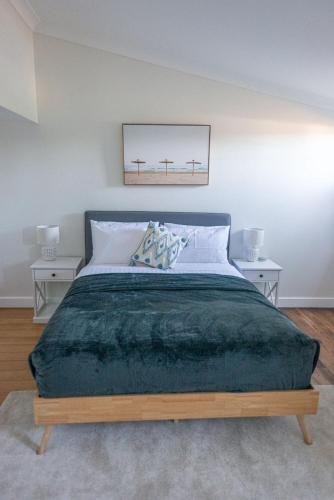 a bedroom with a large bed with two tables at The Ranch-pool Table, Table Tennis, Firepit, Piano in Stanthorpe