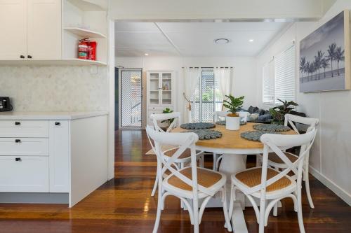 a kitchen and dining room with a table and chairs at Acacia Ridge Cottage - Firepit, Kids Cubby, Games in Brisbane