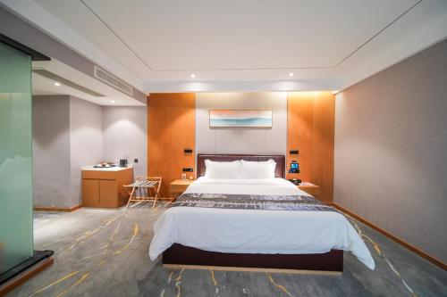 a bedroom with a large bed and a desk at Kelly Jinyue Hotel in Chengdu