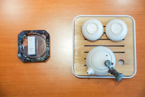 a box with two cups and a clock on a table at Kelly Jinyue Hotel in Chengdu