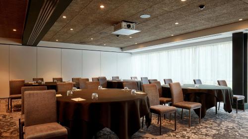 a conference room with tables and chairs and a large window at voco Leicester by IHG in Leicester