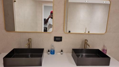 a person taking a picture of a bathroom with two sinks at La Villa Toscana: Pool & Elah Valley vineyard view in Adderet