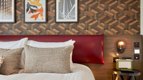 a bedroom with a bed with a red headboard at voco Leicester by IHG in Leicester