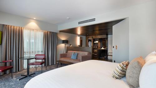 a hotel room with a bed and a living room at voco Leicester by IHG in Leicester