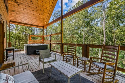 a screened in porch with chairs and a tub at Honeysuckle Hill cabin in Sevierville