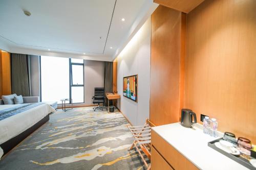 a hotel room with a bed and a desk and a sink at Kelly Jinyue Hotel in Chengdu