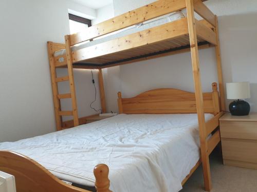 a bedroom with two bunk beds with white sheets at Plein Ciel sur les pistes 40m2 - 2 chambres in Allevard