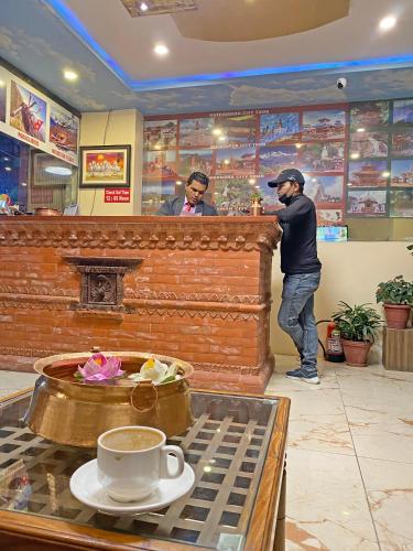 two men standing at a bar in a restaurant at Hotel Airport Holiday in Kathmandu