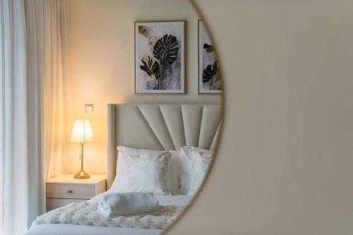 a bedroom with a bed with two pictures on the wall at Nasma - Modern 3BR Oasis with Balcony in Azizi Riviera in Dubai