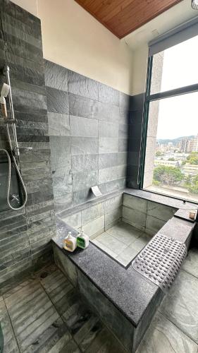 a bathroom with a shower with a bench and a window at 天天泡湯 in Yilan City