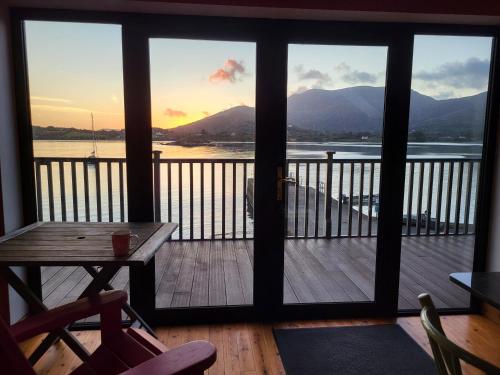a porch with a table and a view of the water at The Boat House in Adrigole