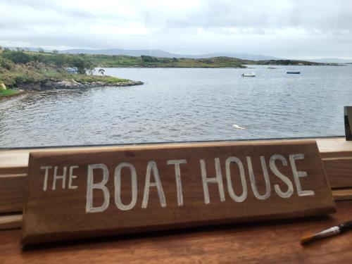 a boat house sign with a view of a body of water at The Boat House in Adrigole