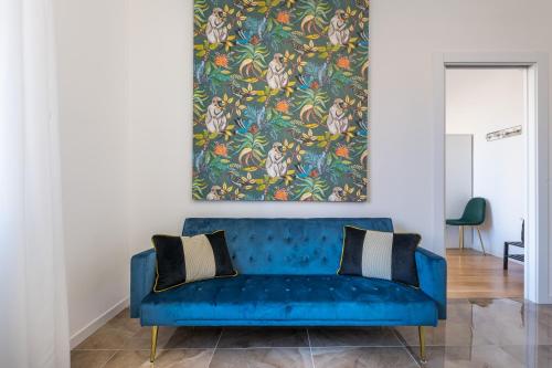 niebieska kanapa w salonie z obrazem na ścianie w obiekcie Suite Speciosa Bestvacationever w Cagliari