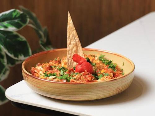 a wooden bowl of food with a tortilla in it at فندق المدينة القديمة Old Town Hotel in Nizwa