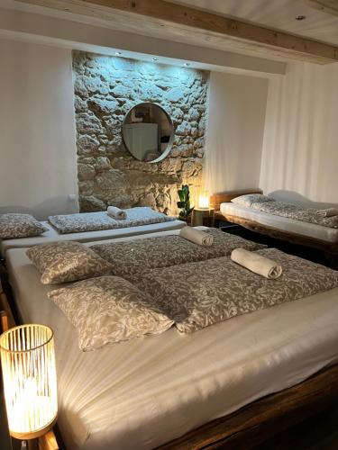 a bedroom with two beds and a stone wall at Hacienda Napoli in Sebechleby