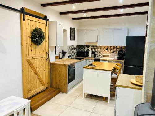 a kitchen with white cabinets and a wooden door at Hacienda Napoli in Sebechleby