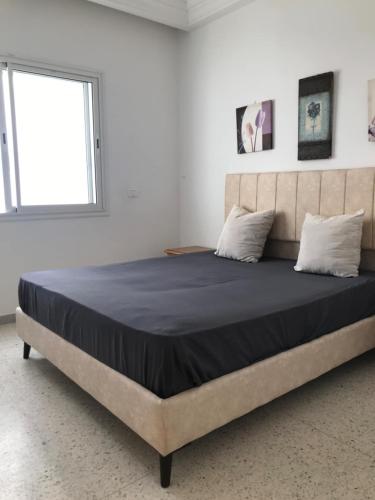 a large bed in a room with a window at Adam beautiful loft in Nabeul