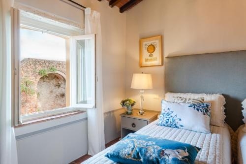 a bedroom with a bed and a window at Montecarlo Wine Apartment in Montecarlo