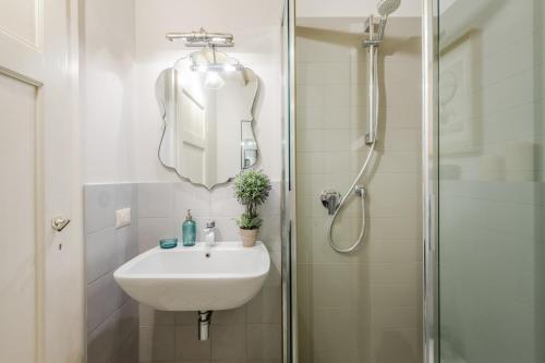 a bathroom with a sink and a shower with a mirror at Montecarlo Wine Apartment in Montecarlo