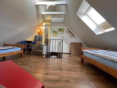 a attic room with two beds and a table at Seestern in Norddeich