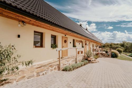 a house with a brick driveway next to a building at Hacienda Napoli in Sebechleby