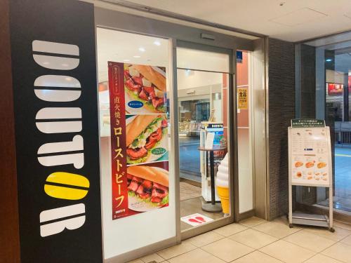 an entrance to a fast food restaurant with a sandwich sign at Meitetsu Inn Kariya in Kariya