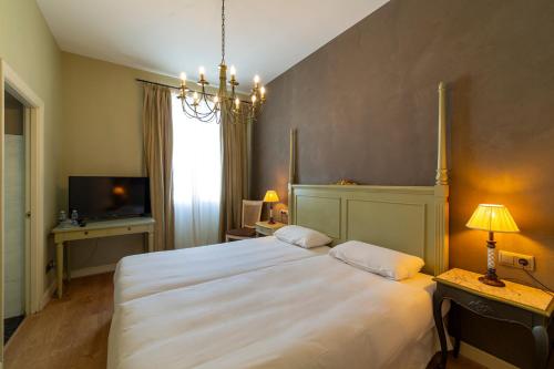 a bedroom with a large white bed and a television at KAIAN MAITEA in Plentzia