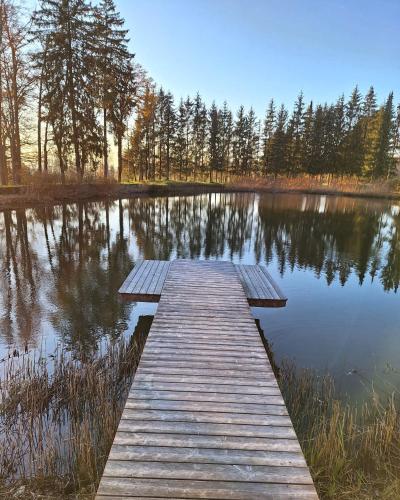 a wooden dock in the middle of a lake at Rosenhof Salzburger Seenland in Strasswalchen