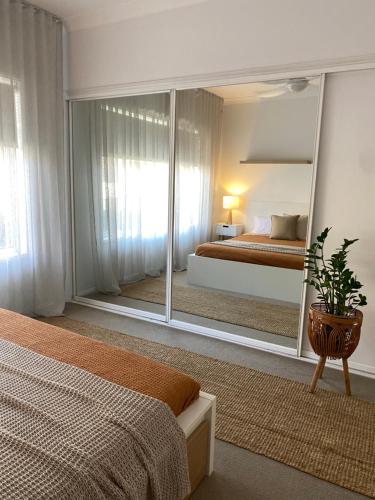 a bedroom with two beds and a large mirror at Tweed River Holiday House in Tweed Heads