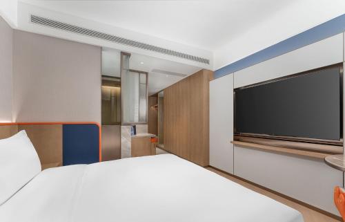 a bedroom with a large bed and a flat screen tv at Holiday Inn Express Datong Pingcheng by IHG in Datong
