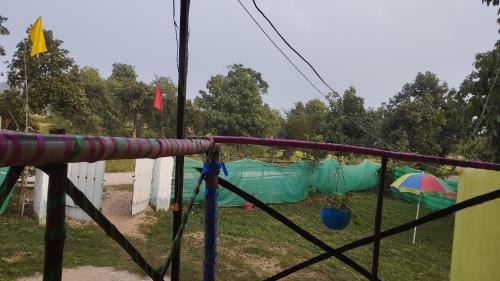 a playground with a tent and an umbrella at PALASH Pahar Resort in Jhalida
