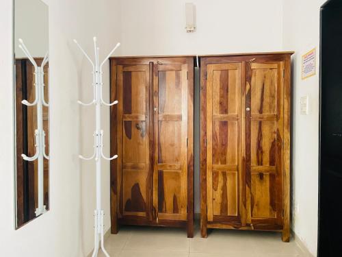 a pair of wooden cabinets in a room at Lifespace- Spacious Hostel in a Luxurious Villa in Pune
