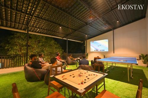 a group of people sitting in a room with a ping pong table at EKOSTAY - Serenity Villa in Alibaug