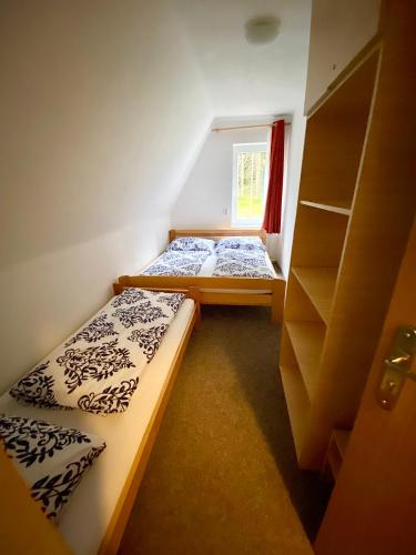two beds in a small room with a window at Severka in Háj