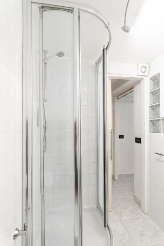 a shower with a glass door in a bathroom at Rifugio storico a 50 passi dal Duomo, Bilocale in Genoa